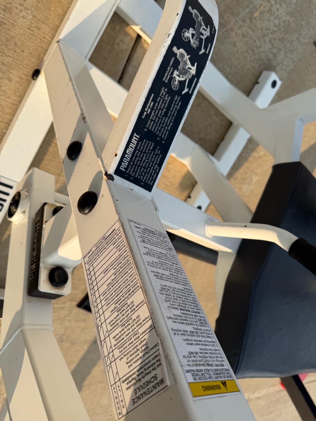 a close-up view of a piece of exercise equipment, possibly a weight machine or a pull-up bar, with a label or instructions attached to it.