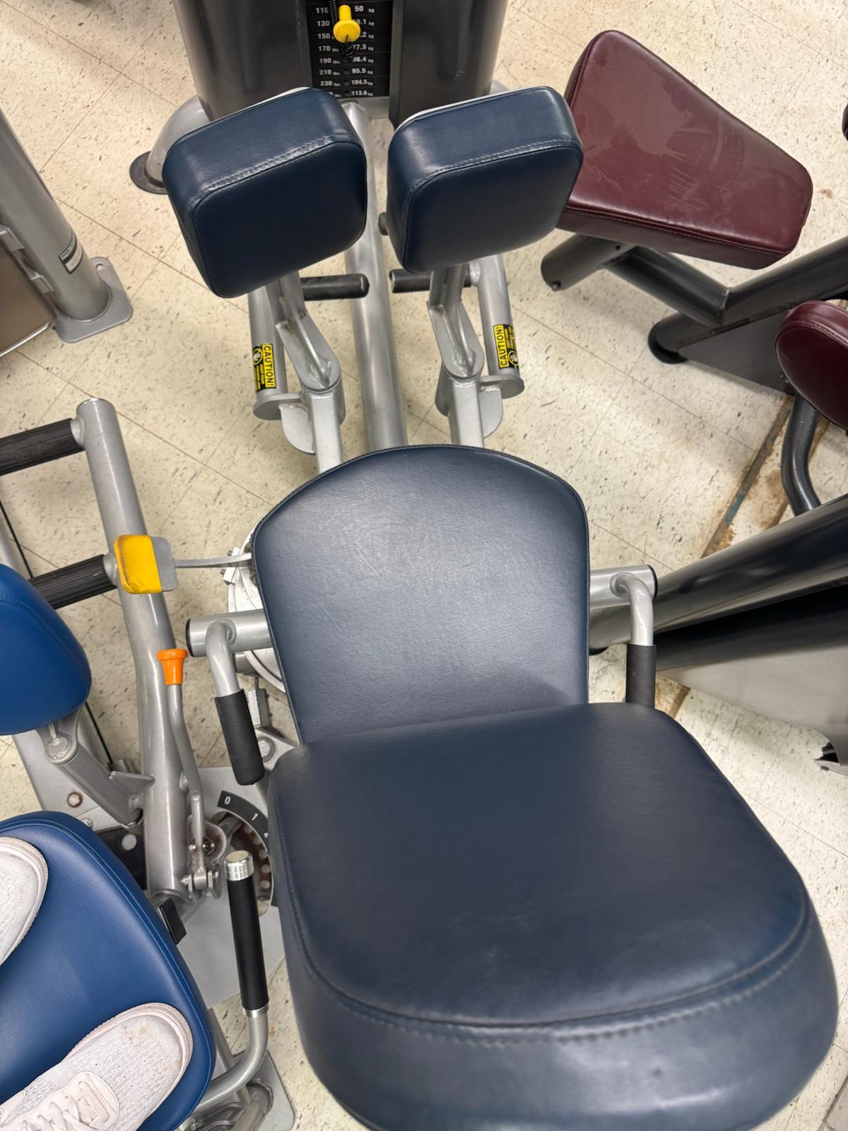 a gym setting with various exercise equipment, including a blue and black exercise machine and a red exercise machine.