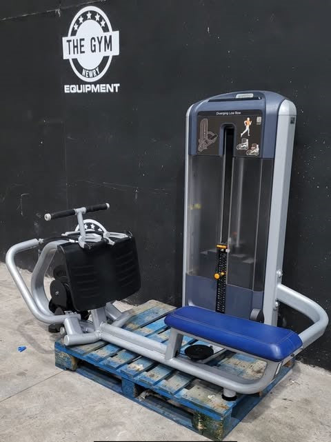 a weight training machine, specifically a leg press, placed on a blue wooden pallet against a black wall with a logo for "THE GYM" and "EQUIPMENT".