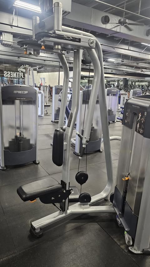 a well-equipped gym with various exercise machines, including a large weight machine with a seat and handles.