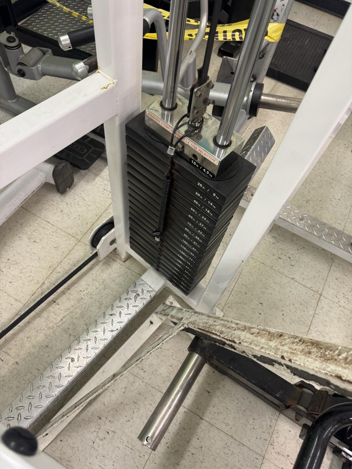 a close-up view of a weight training machine, focusing on the weight plates and the metal frame.
