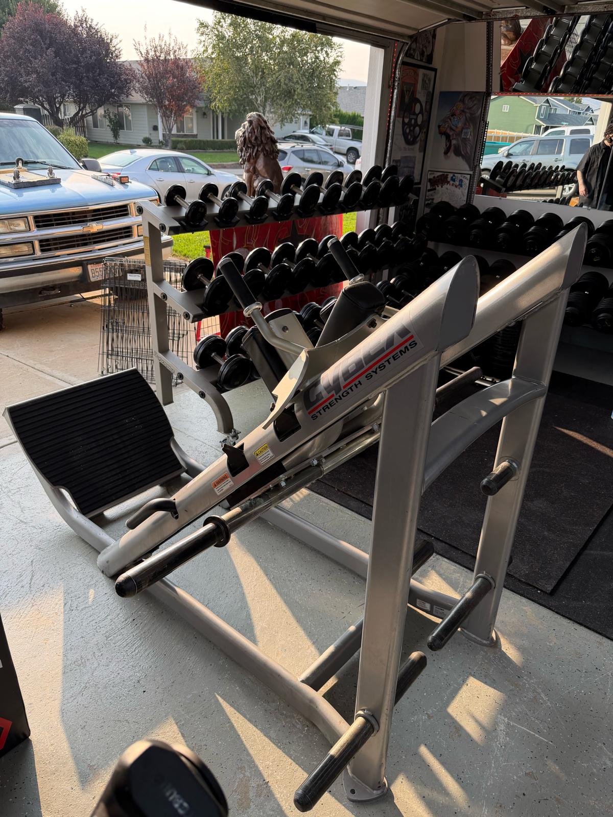a weight training setup with various weight racks and dumbbells, indicating a fitness or gym environment.
