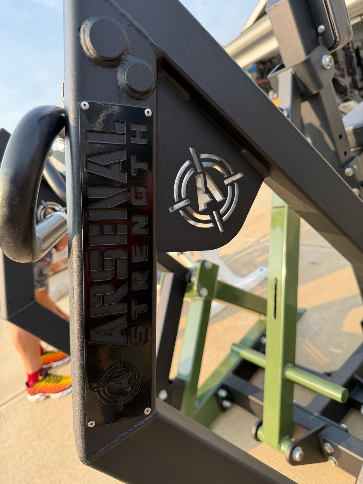 a close-up view of a black metal frame with the word "Arsenal" written on it, along with a logo featuring a cross and an arrow.