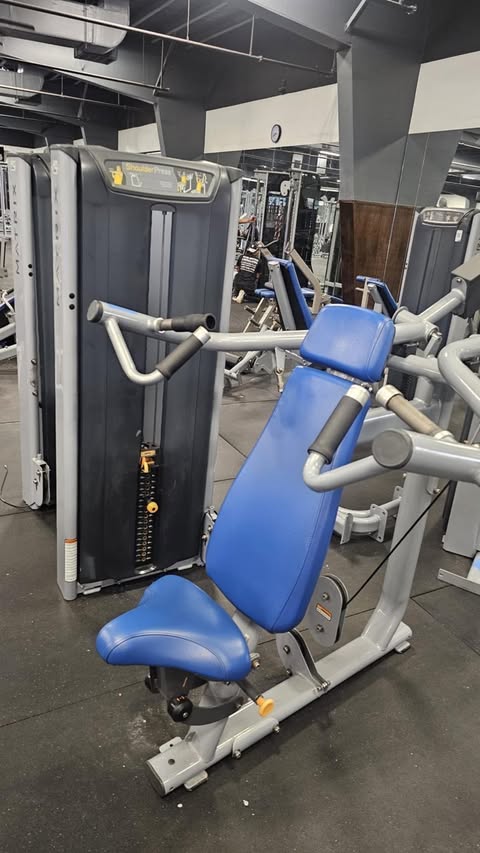 a well-equipped gym with various exercise machines, including a blue and gray weight machine.